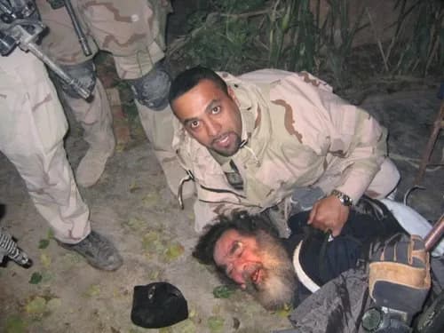 Saddam Hussein wordt uit zijn schuilplaats getrokken en gevangen genomen