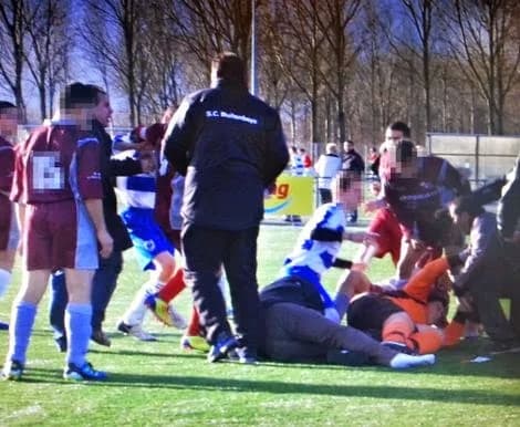 Grensrechter Richard Nieuwenhuizen (midden foto zonder schoen en inzet) wordt in elkaar geschopt door spelers van de Amsterdamse club Nieuw-Sloten na afloop van de wedstrijd
